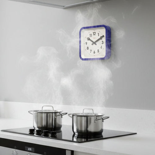 Modern kitchen with white cabinetry, a stove, and a clock on the wall.
